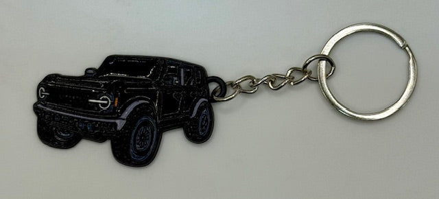 Black truck-shaped keychain on a white background